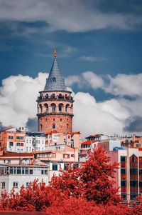 Buildings in city against cloudy sky