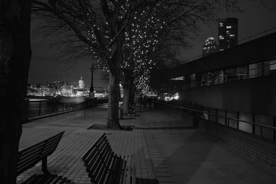 Illuminated street amidst buildings in city at night