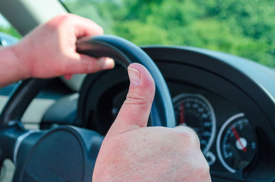 Cropped hands of man traveling in car