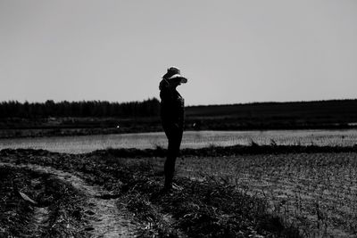 Full length of man walking on field against clear sky