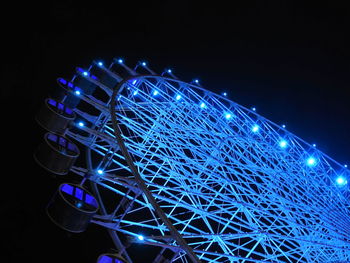 Low angle view of illuminated ferris wheel against sky at night