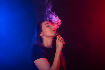 Beautiful young woman against black background