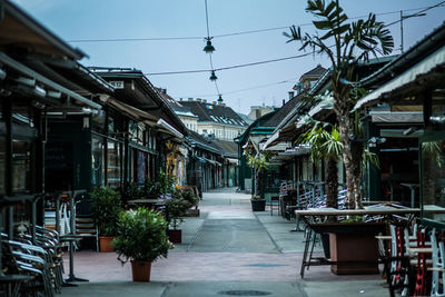 Alley amidst buildings in city against clear sky