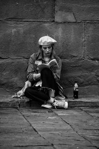 Portrait of woman sitting on wall