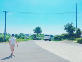 Rear view of man walking on road