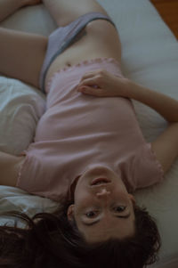 High angle portrait of woman lying on bed