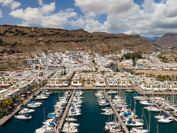 Aerial view of townscape and harbor against sky