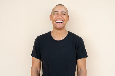 Portrait of young man standing against white background