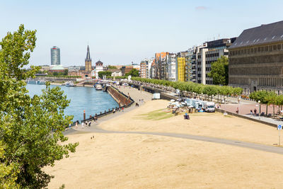 View of buildings by river against sky