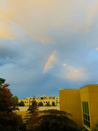 Low angle view of rainbow over buildings in city