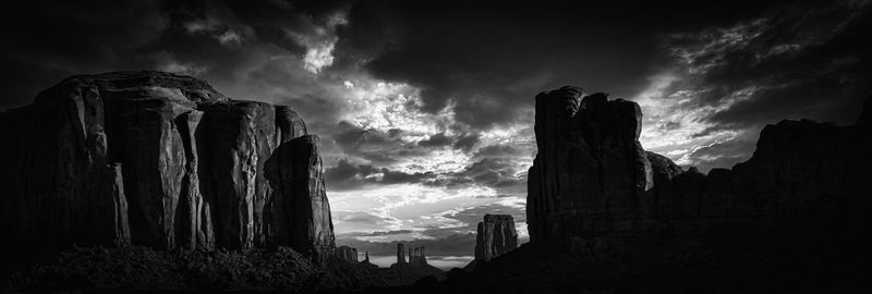 Panoramic view of rock formations against cloudy sky