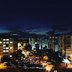 Illuminated cityscape against sky at night