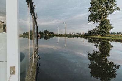 Houseboat on yser river under cloudy sky