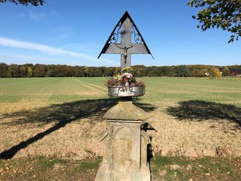 Traditional windmill on field against sky