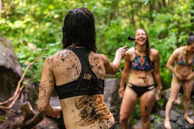 Rear view of people running in forest