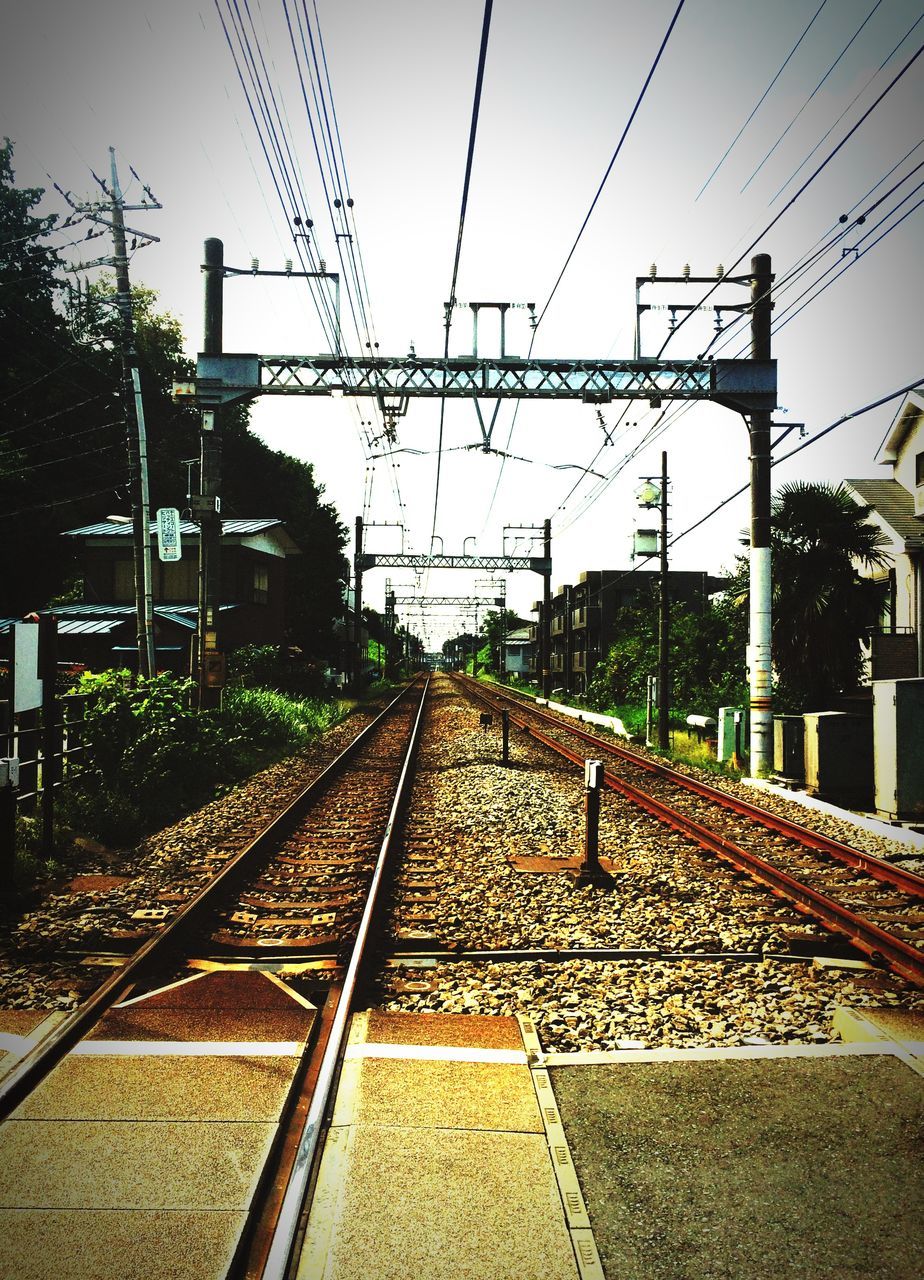 railroad track, rail transportation, power line, transportation, electricity pylon, public transportation, power supply, railroad station, railroad station platform, electricity, clear sky, railway track, diminishing perspective, cable, sky, the way forward, fuel and power generation, vanishing point, connection, power cable