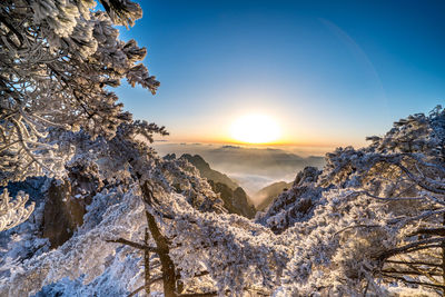 Scenic view of snowcapped mountains against sky at sunset