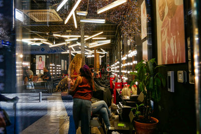 Rear view of people sitting on street at night