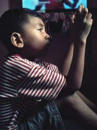 Side view of boy sitting at home