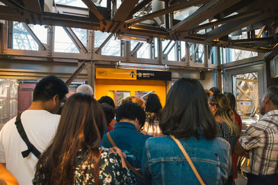 Rear view of people standing in city