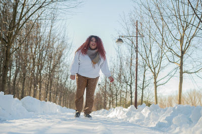 Young woman standing on snow covered landscape