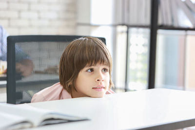 Portrait of boy looking through window