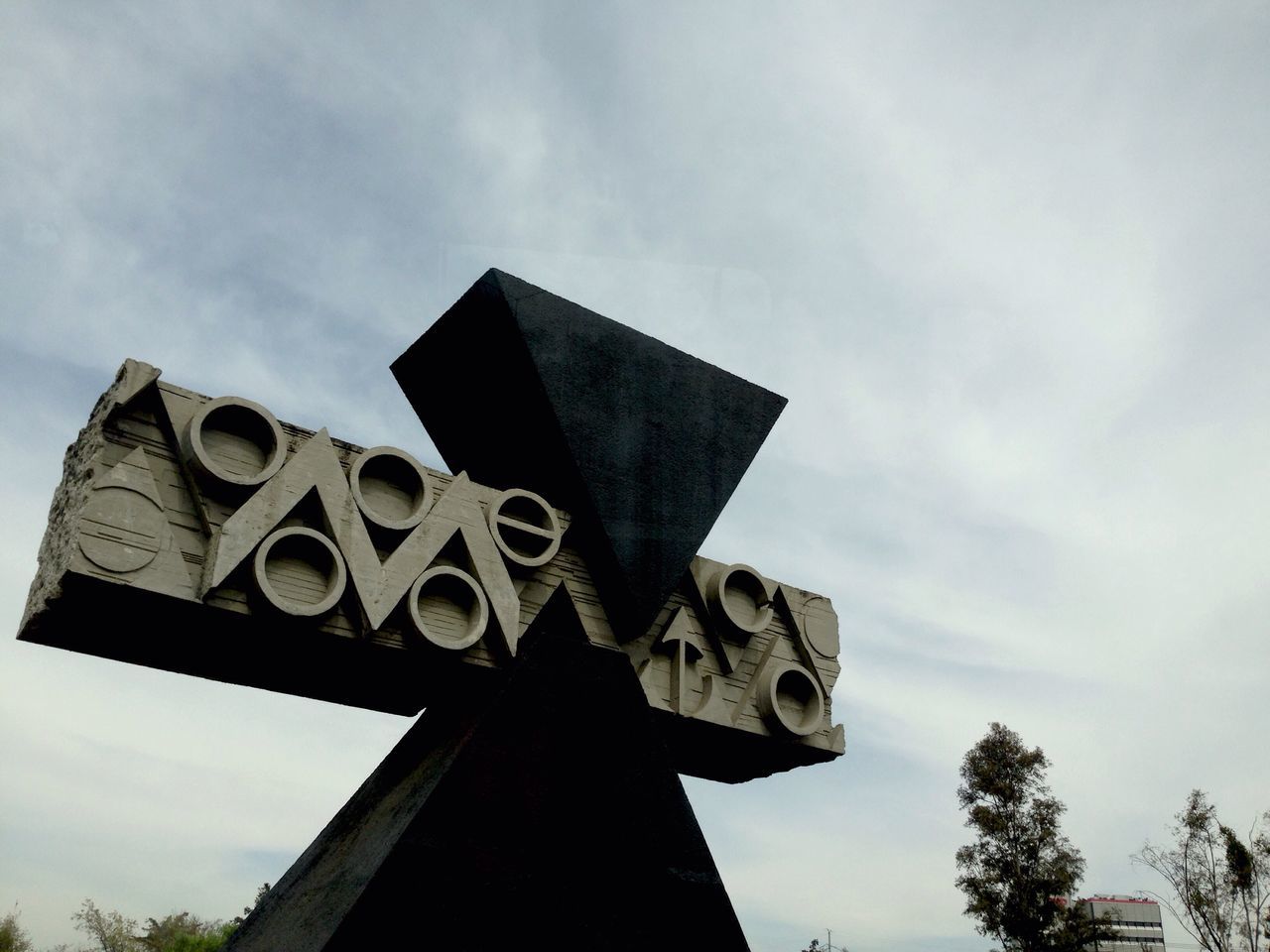 low angle view, religion, spirituality, sky, place of worship, architecture, built structure, building exterior, church, cross, history, old, no people, high section, day, cloud - sky, outdoors, tree