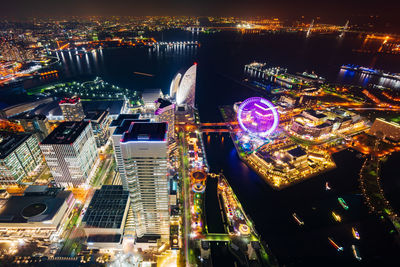 Aerial view of river amidst illuminated buildings at night