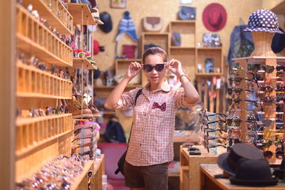 Portrait of woman wearing sunglasses while standing in store