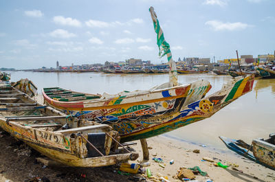 Boats moored at beach against sky