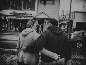 Rear view of people standing on street in city