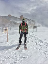 Man snowboarding on mountain against sky
