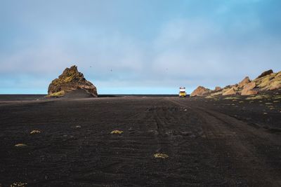 Rock formations on beach against sky