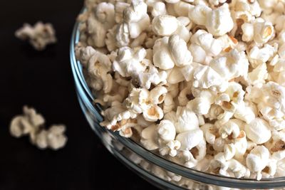 Close-up of popcorns in bowl over black background