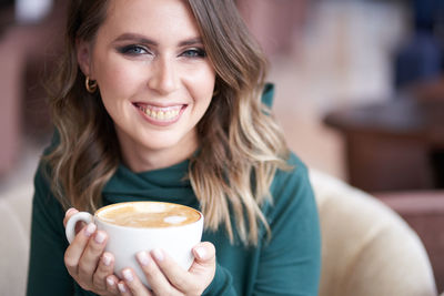 Smiling woman with coffee cup at cafe