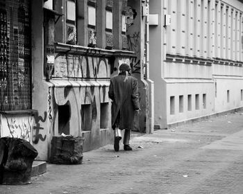 Rear view of man walking on street in city