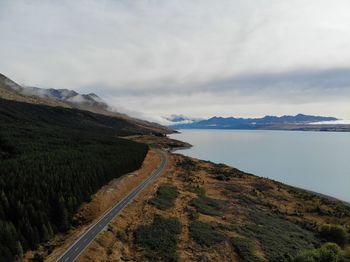 Scenic view of road by mountain against sky