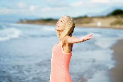 Smiling woman standing at beach