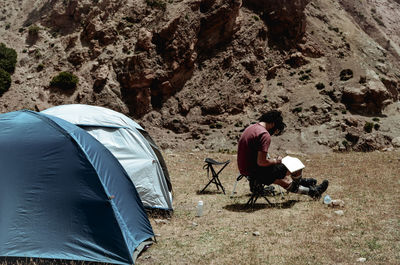 High angle view of man sitting on tent