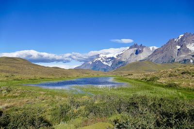 Scenic view of mountains against blue sky