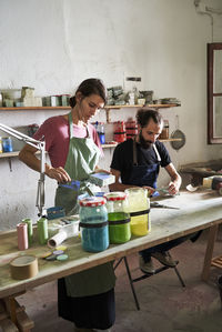 Male and female craftsperson making concrete design in workshop