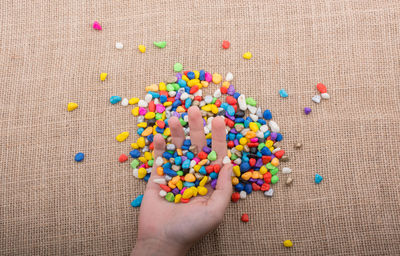 Close-up of hand with colorful stones at table