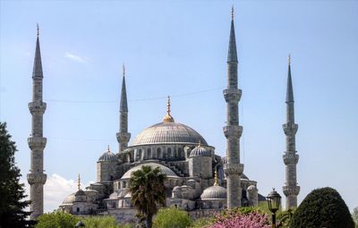 Low angle view of mosque against clear blue sky