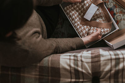 Midsection of man using laptop while sitting on bed at home