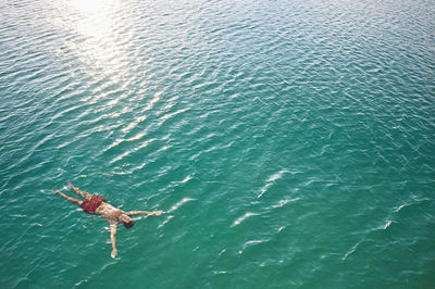 Mature man floating in emerald water