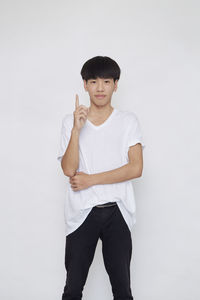 Portrait of boy standing against white background
