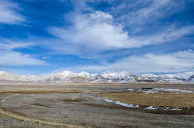 Scenic view of snowcapped mountains against blue sky