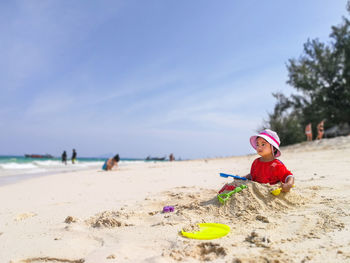 Cute girl buried in sand at beach