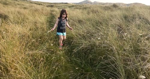 Full length of girl walking on grassy field