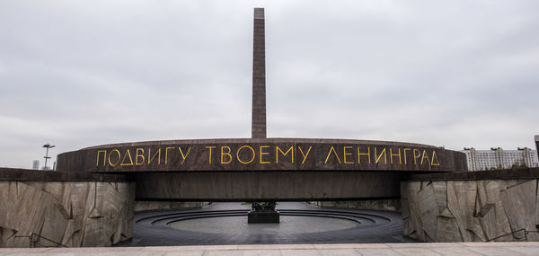 Information sign in factory against sky